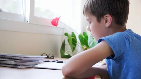 Learning difficulties. Sad tired boy doing school homework Vídeo Stock 128484582