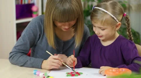 Learning to Draw. Mother and child are sitting at the table. They paint the f Stock Footage 18720683