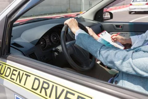 Learning to drive a car with a driving instructor. Student driver. Stock Photos