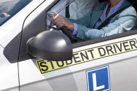 Learning to drive a car with a driving instructor. Student driver. Stock Photos