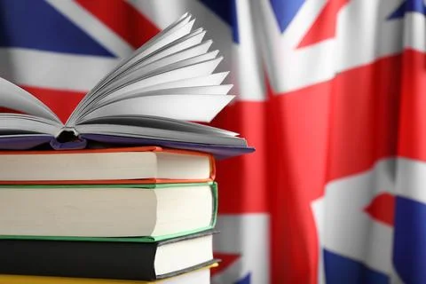 Learning foreign language. Different books against flag of United Kingdom, .. Stock Photos