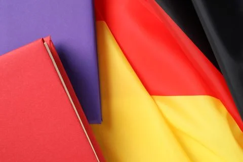 Learning foreign language. Different books on flag of Germany, top view wit.. Stock Photos