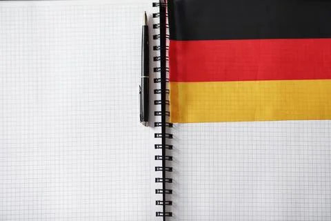 Learning foreign languages. Notepad for entries and a flag. Language course.. Stock Photos