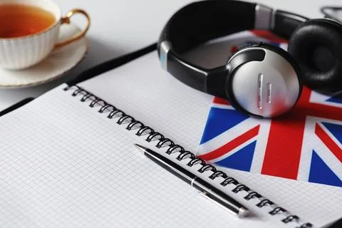 Learning foreign languages. Notepad for entries and a flag. Language course.. Stock Photos