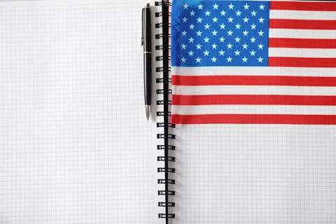 Learning foreign languages. Notepad for entries and a flag. Language course.. Stock Photos