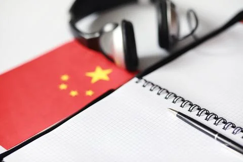 Learning foreign languages. Notepad for entries and a flag. Language course.. Stock Photos