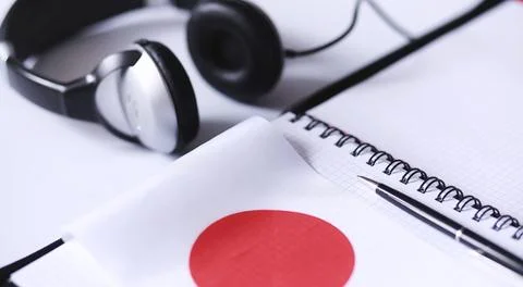 Learning foreign languages. Notepad for entries and a flag. Language course.. Stock Photos
