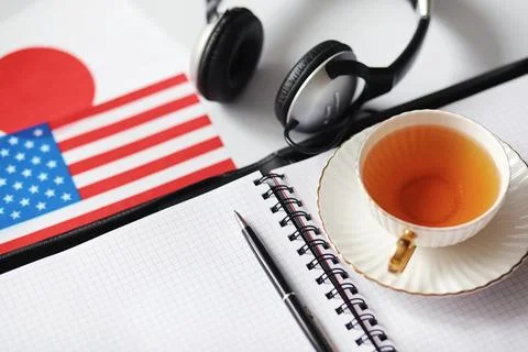 Learning foreign languages. Notepad for entries and a flag. Language course.. Stock Photos