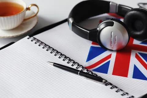 Learning foreign languages. Notepad for entries and a flag. Language course.. Stock Photos