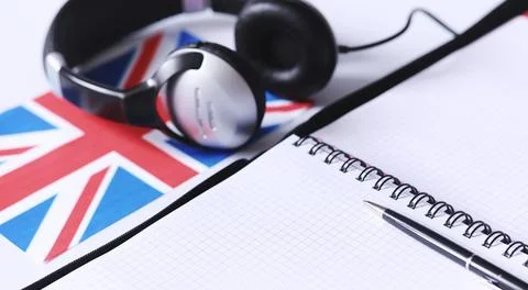 Learning foreign languages. Notepad for entries and a flag. Language course.. Stock Photos
