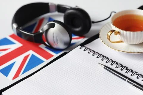 Learning foreign languages. Notepad for entries and a flag. Language course.. Stock Photos
