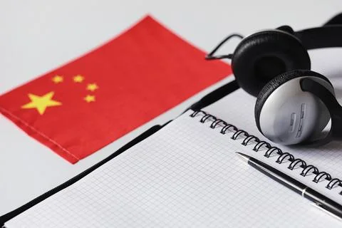 Learning foreign languages. Notepad for entries and a flag. Language course.. Stock Photos