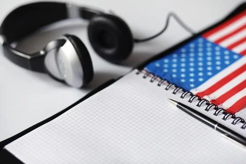 Learning foreign languages. Notepad for entries and a flag. Language course.. Stock Photos
