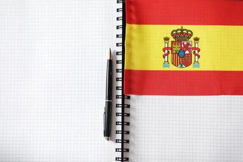 Learning foreign languages. Notepad for entries and a flag. Language course.. Stock Photos