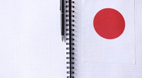 Learning foreign languages. Notepad for entries and a flag. Language course.. Stock Photos