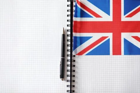 Learning foreign languages. Notepad for entries and a flag. Language course.. Stock Photos