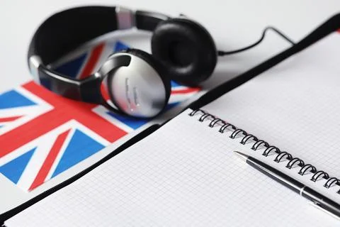 Learning foreign languages. Notepad for entries and a flag. Language course.. Stock Photos