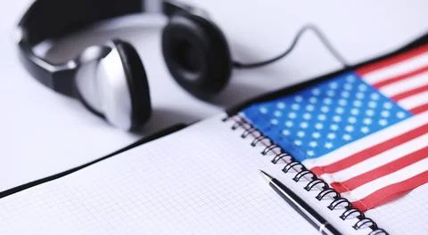 Learning foreign languages. Notepad for entries and a flag. Language course.. Stock Photos