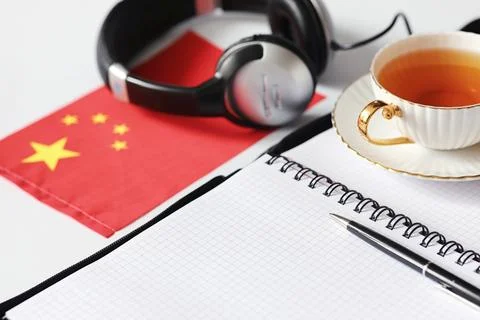 Learning foreign languages. Notepad for entries and a flag. Language course.. Stock Photos