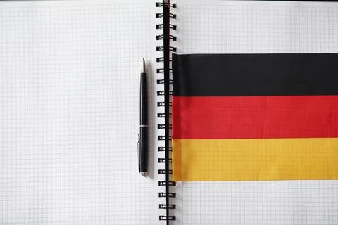Learning foreign languages. Notepad for entries and a flag. Language course.. Stock Photos