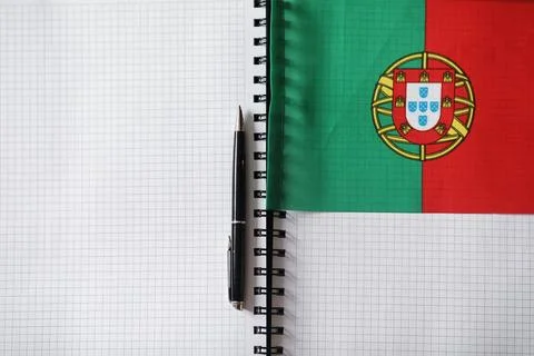 Learning foreign languages. Notepad for entries and a flag. Language course.. Stock Photos