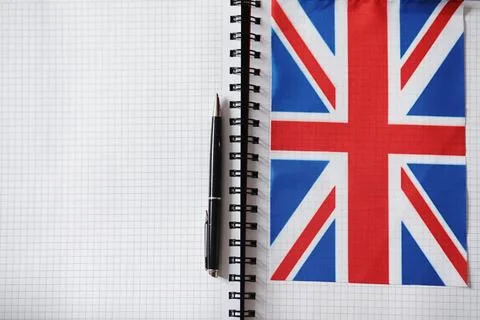 Learning foreign languages. Notepad for entries and a flag. Language course.. Stock Photos