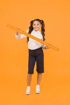 Learning geometry at school. Small school child holding measuring device on Stock Photos