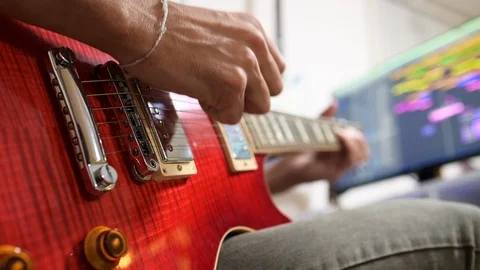 Learning at home to play the guitar Stock Footage 128735409