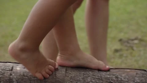 Learning How to Walk on a Thick Wooden Branch Holding Hands with Grown Up Stock Footage 263965861