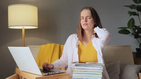 Learning from a laptop. Online college classes. Tired young woman studying at Stock Footage 254767548