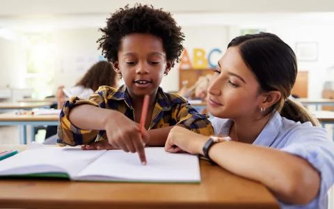 Learning made fun. Shot of a female teacher assisting a preschool learner in her Stock Photos