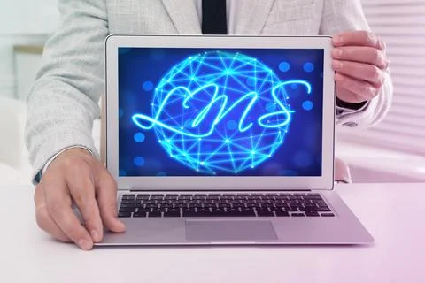 Learning management system. Man showing modern laptop at table, closeup. Di.. 스톡 사진