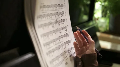 Learning music at home, hand making notes on sheet music. old vintage interior Video stock 310137287