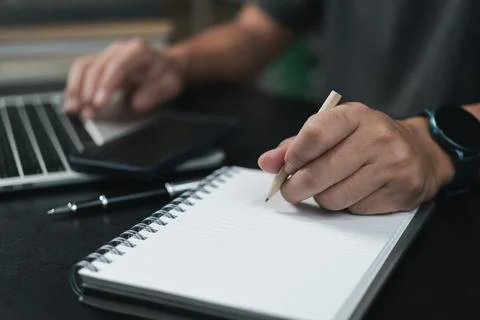 Learning online class by using laptop computer and writing notebook at work.. 스톡 사진
