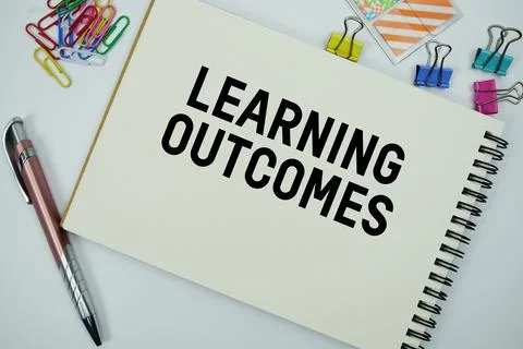 Learning Outcomes text message written on notepad with stationery flat lay .. Stock Photos