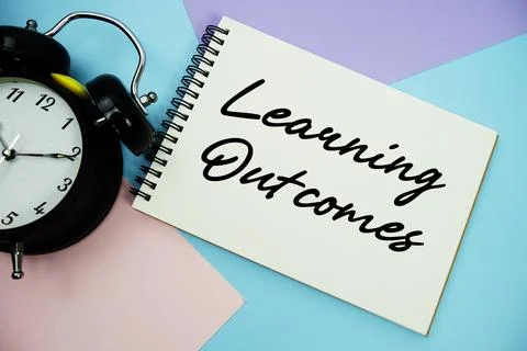 Learning Outcomes text written on notepad with alarm clock flat lay on mult.. Stock Photos