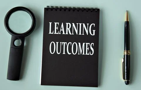 LEARNING OUTCOMES - words on a black notebook with a magnifying glass and p.. Stock Photos