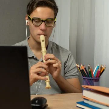 Learning to play the flute online. Playing wind instruments Stock Photos