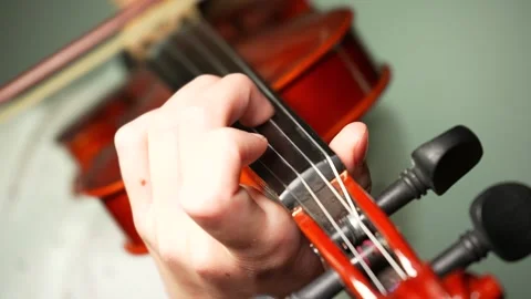 Learning to play the violin. Closeup fingers on the neck of violin Stock Footage 237385923