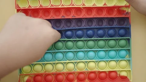 Learning to pop a fidget toy for fun and stress relief Stock Footage 330093228
