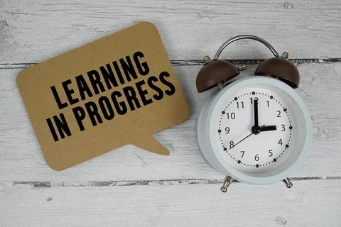 Learning in progress text with alarm clock on wooden background Stock Photos