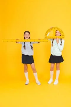 Learning school geometry. School children with measuring instruments on yellow Stock Photos