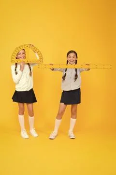 Learning school geometry. School children with measuring instruments on yellow Stock Photos