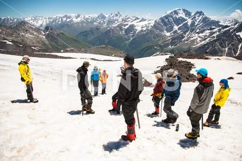 Learning to slip properly on a slope or glacier with an ice ax Stock Photos