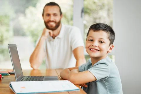 Learning, teaching and smiling little boy doing home school work online on a Foto stock