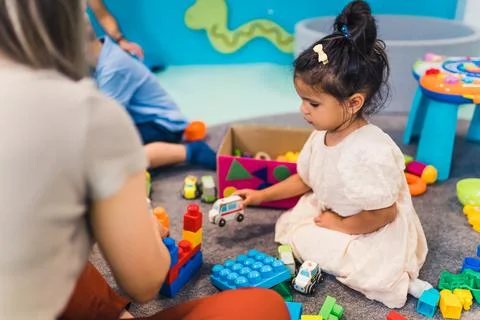 Learning through play at the nursery school. Toddler little girl and the teacher Stock Photos