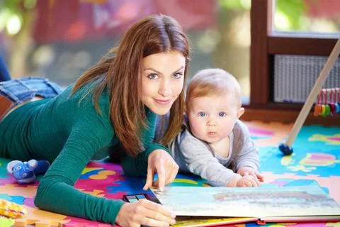 Learning through playtime - Child development. Cute young mom lying alongside Stock Photos