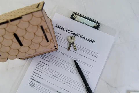 Lease application form with keys and cute house model Stock Photos