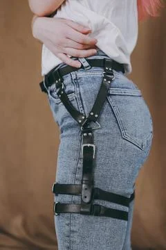 Leather black harnesses on the girl over the clothes Stock Photos
