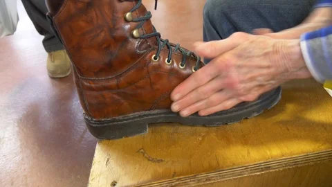 Leather boot being hand polished - two views 4K Stockbeeldmateriaal 101074732